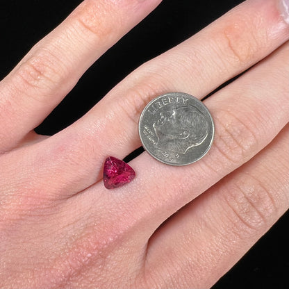 A loose, trillion cut rubellite tourmaline gemstone.