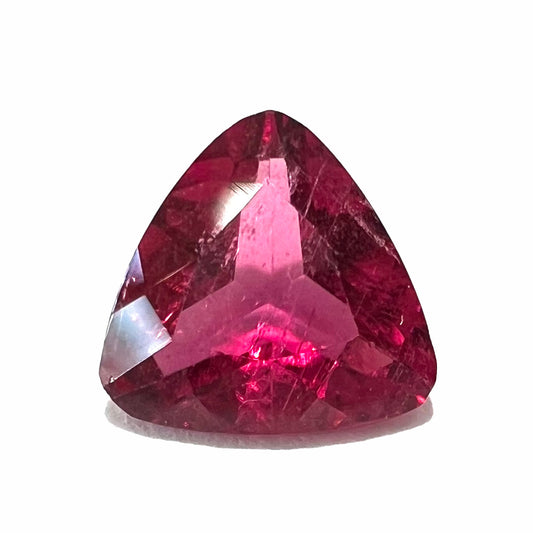 A loose, trillion cut rubellite tourmaline gemstone.