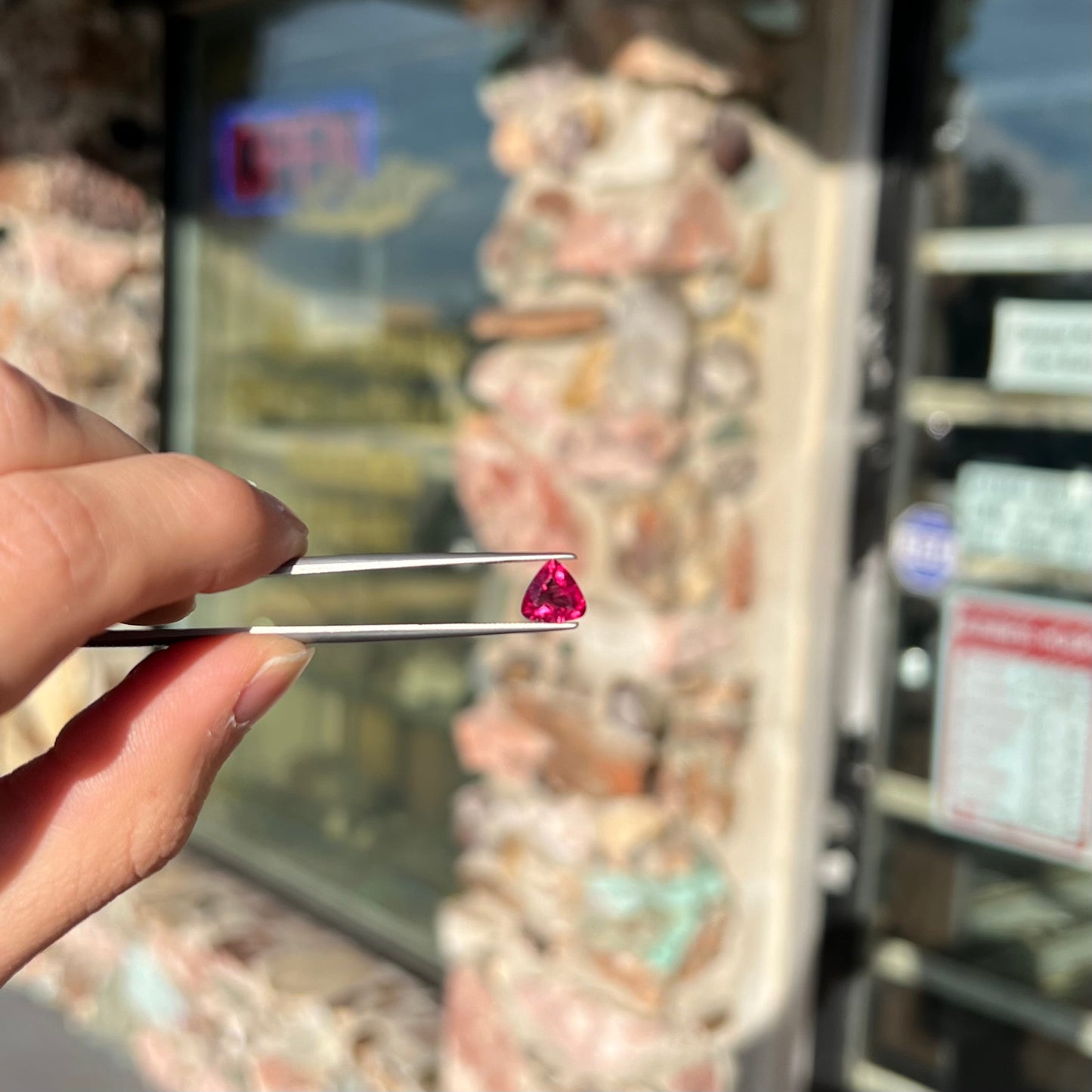 A loose, trillion cut rubellite tourmaline gemstone.