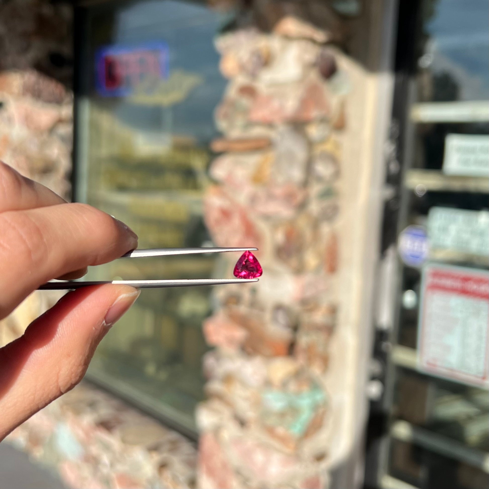 A loose, trillion cut rubellite tourmaline gemstone.