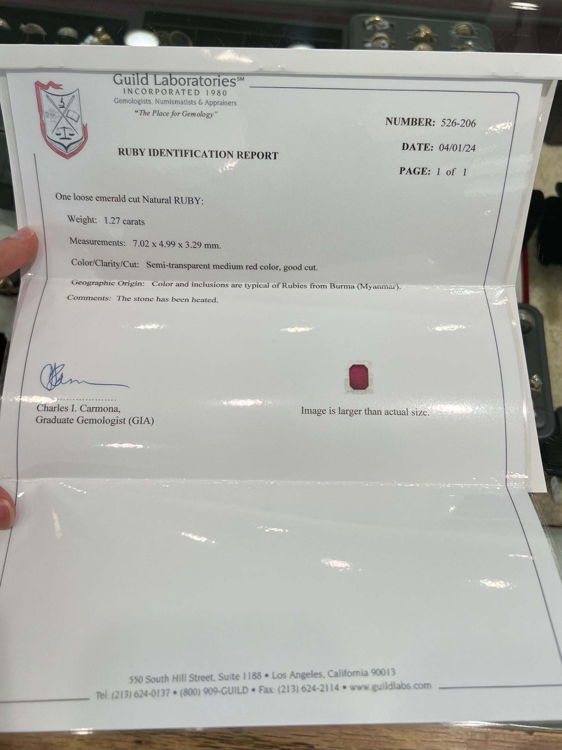 A natural, emerald cut Burma ruby with a purplish pinkish red color.