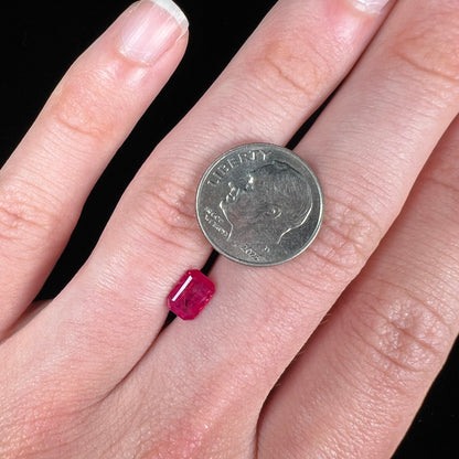 An emerald cut Burma ruby gemstone.  The stone is loose and a pinkish red color.