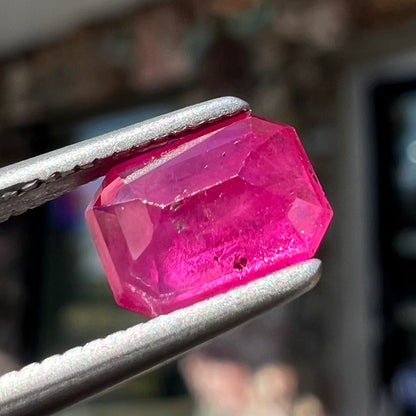 A natural, emerald cut Burma ruby with a purplish pinkish red color.