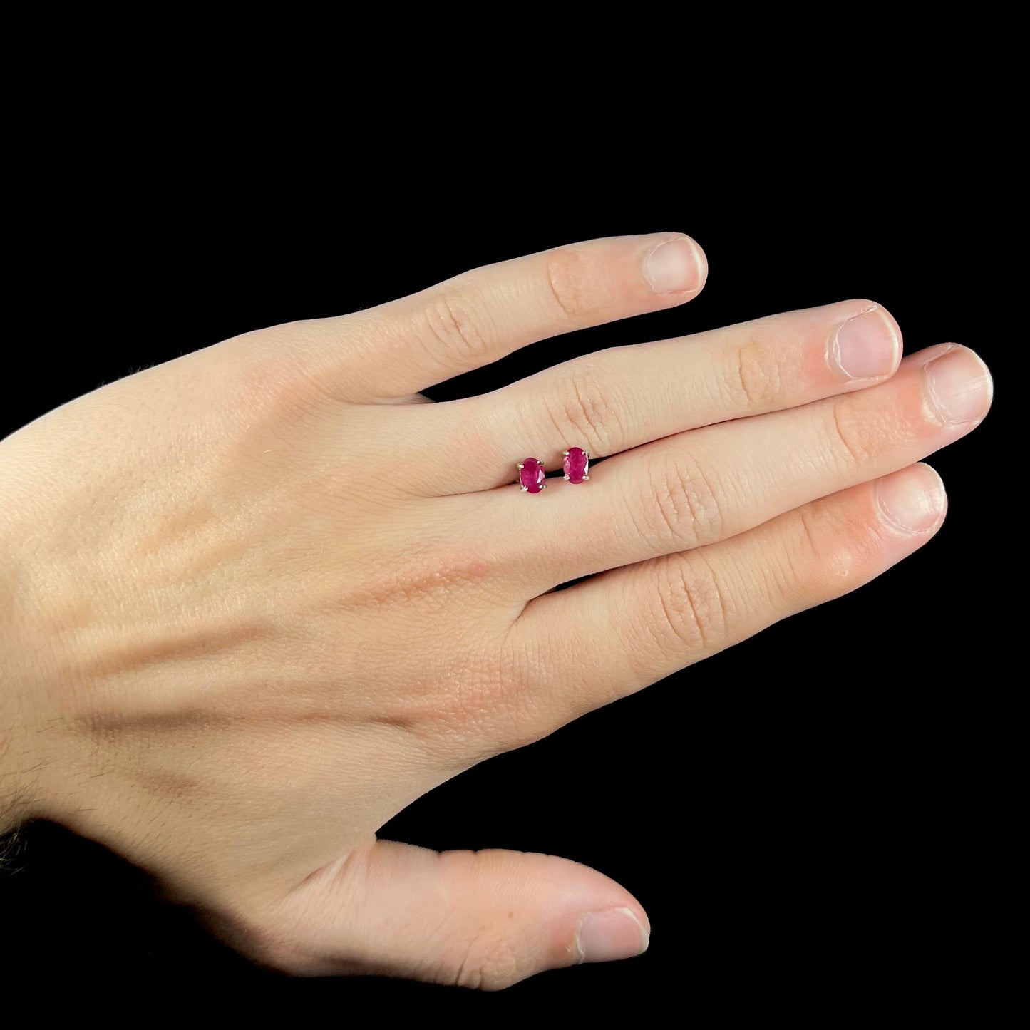 A pair of natural Burma ruby stud earrings set in white gold.  The rubies are a purplish red color.