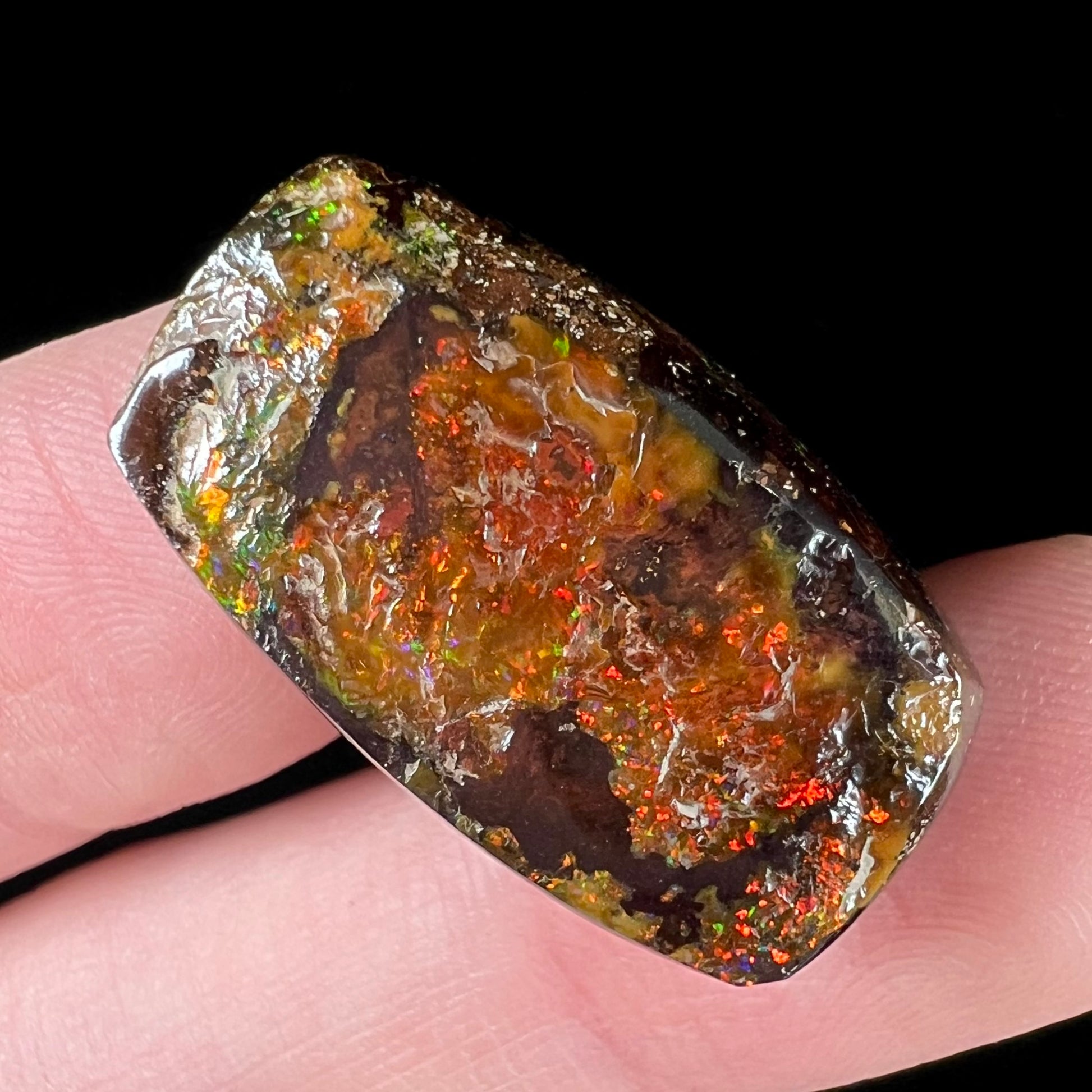 An orange-colored, barrel shaped Australian boulder opal with red fire.