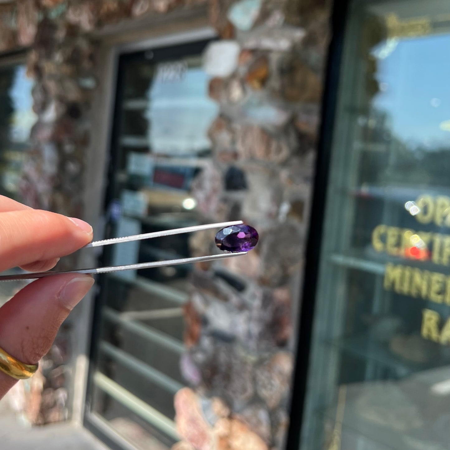 A loose, faceted oval cut Siberian amethyst gemstone.  The stone is purple color with blue and red flashes.