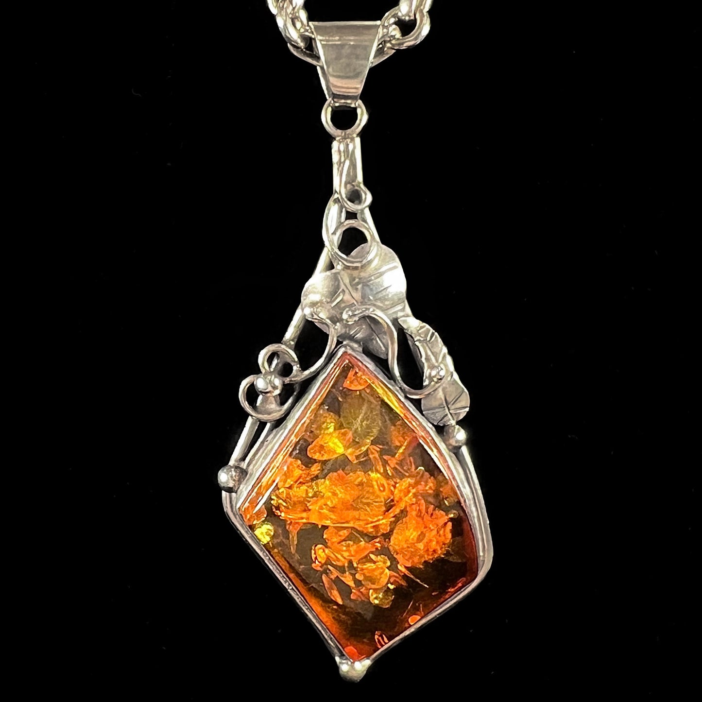 Unisex silver pendant set with a sun-spangled Mexican amber stone, featuring silver leaf design accents.