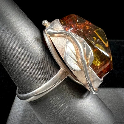 Unisex sterling silver ring set with a large sun-spangled Baltic amber gemstone.