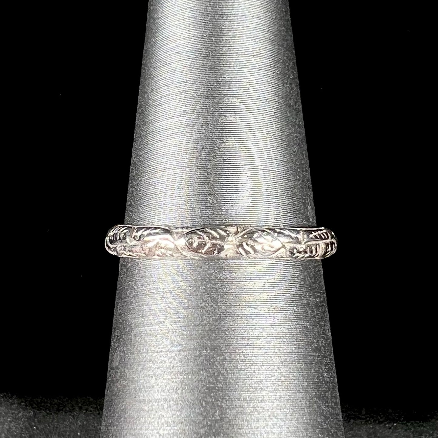 A ladies' sterling silver purple rhodonite garnet solitaire ring.  The shank has an etched floral leaf design.