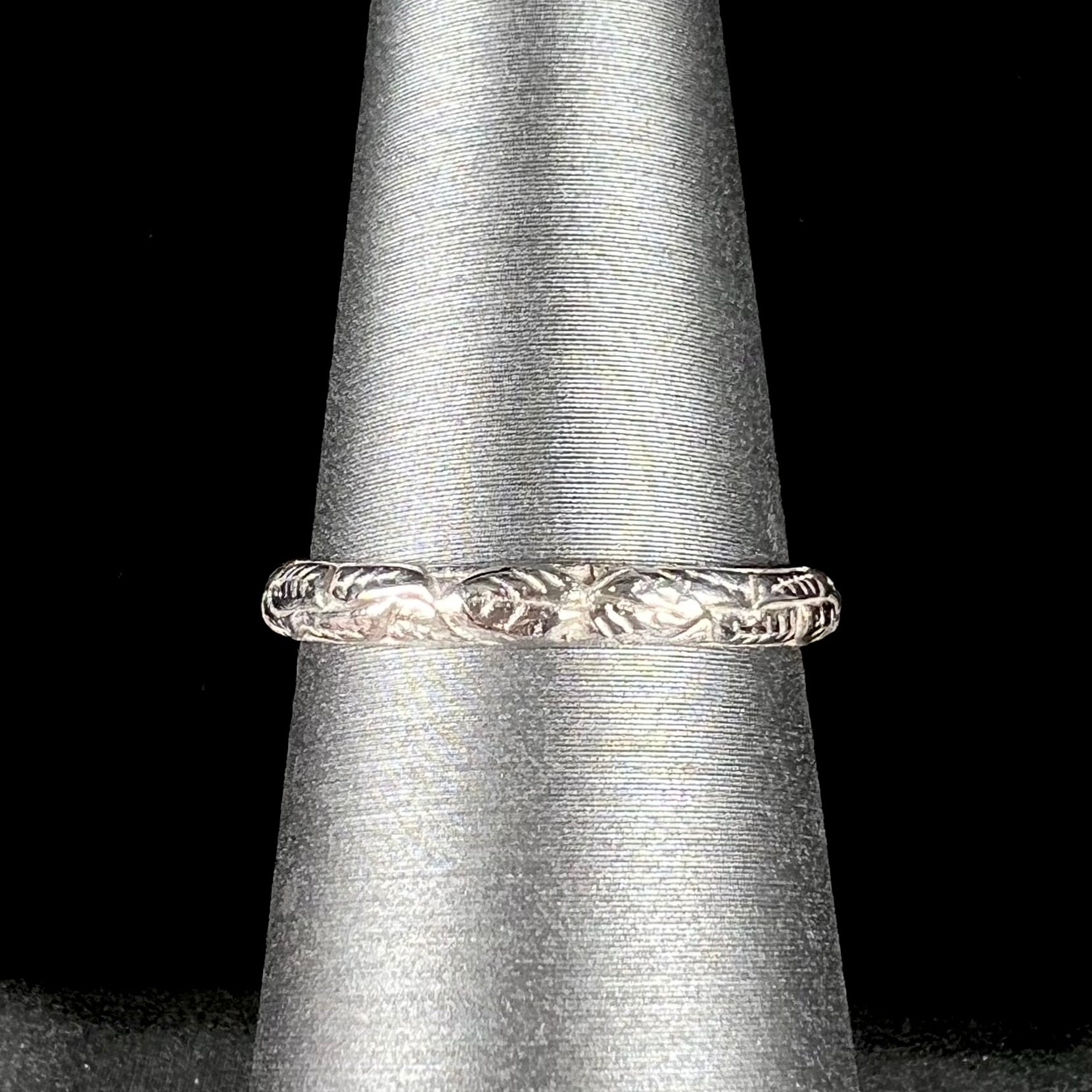 A ladies' sterling silver purple rhodonite garnet solitaire ring.  The shank has an etched floral leaf design.