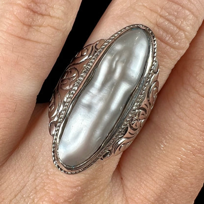 A Boho Chic style sterling silver solitaire ring set with an oval shaped, metallic silver gray mabe pearl.