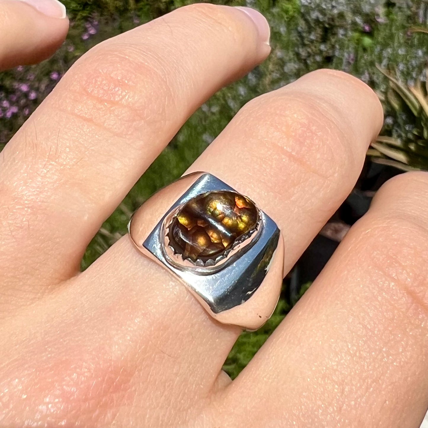 A unisex sterling silver solitaire ring bezel-set with a freeform Mexican fire agate cabochon.  The stone is green and pink.