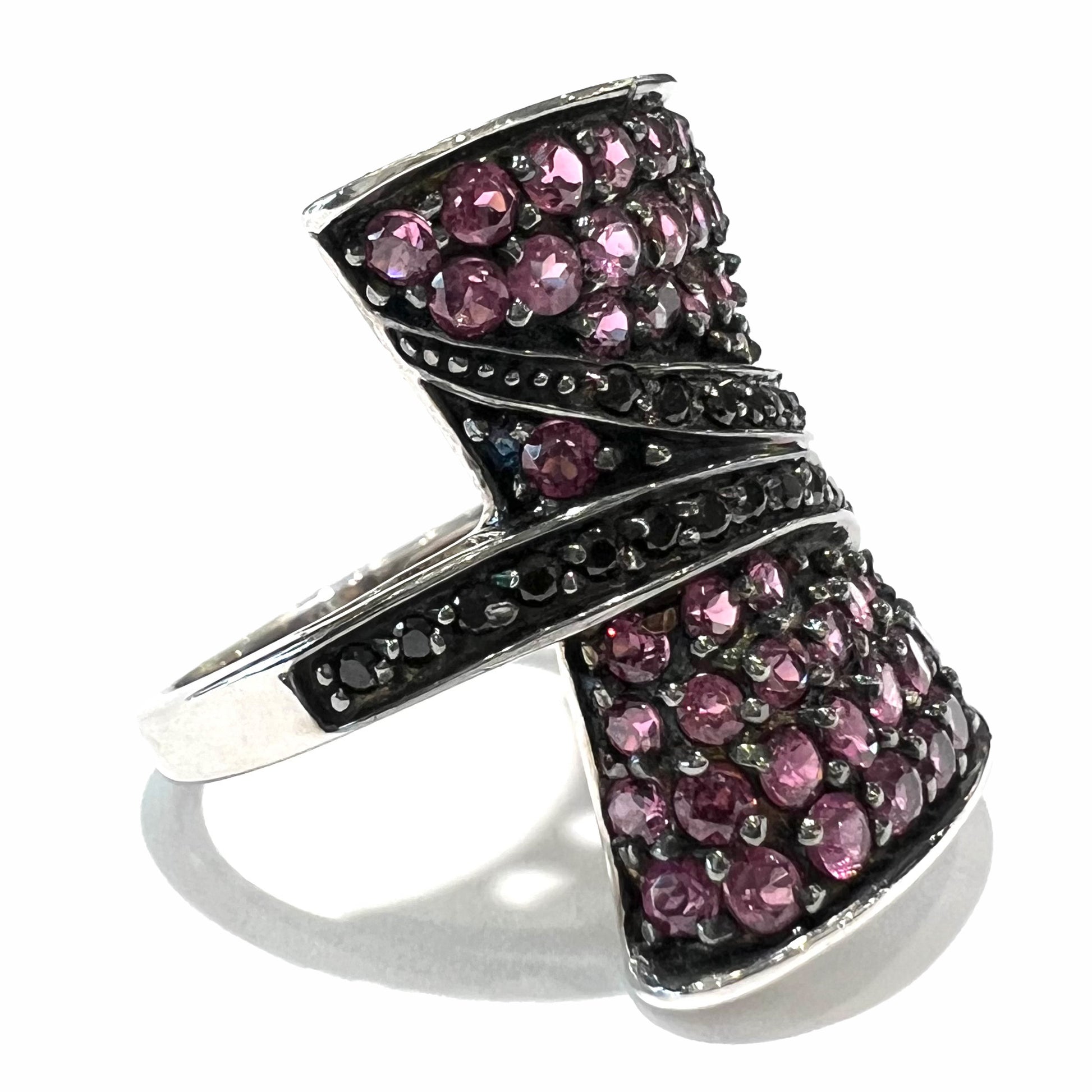 A ladies' bow-shaped designer ring pave set with purple rhodolite garnets and black spinel accents.