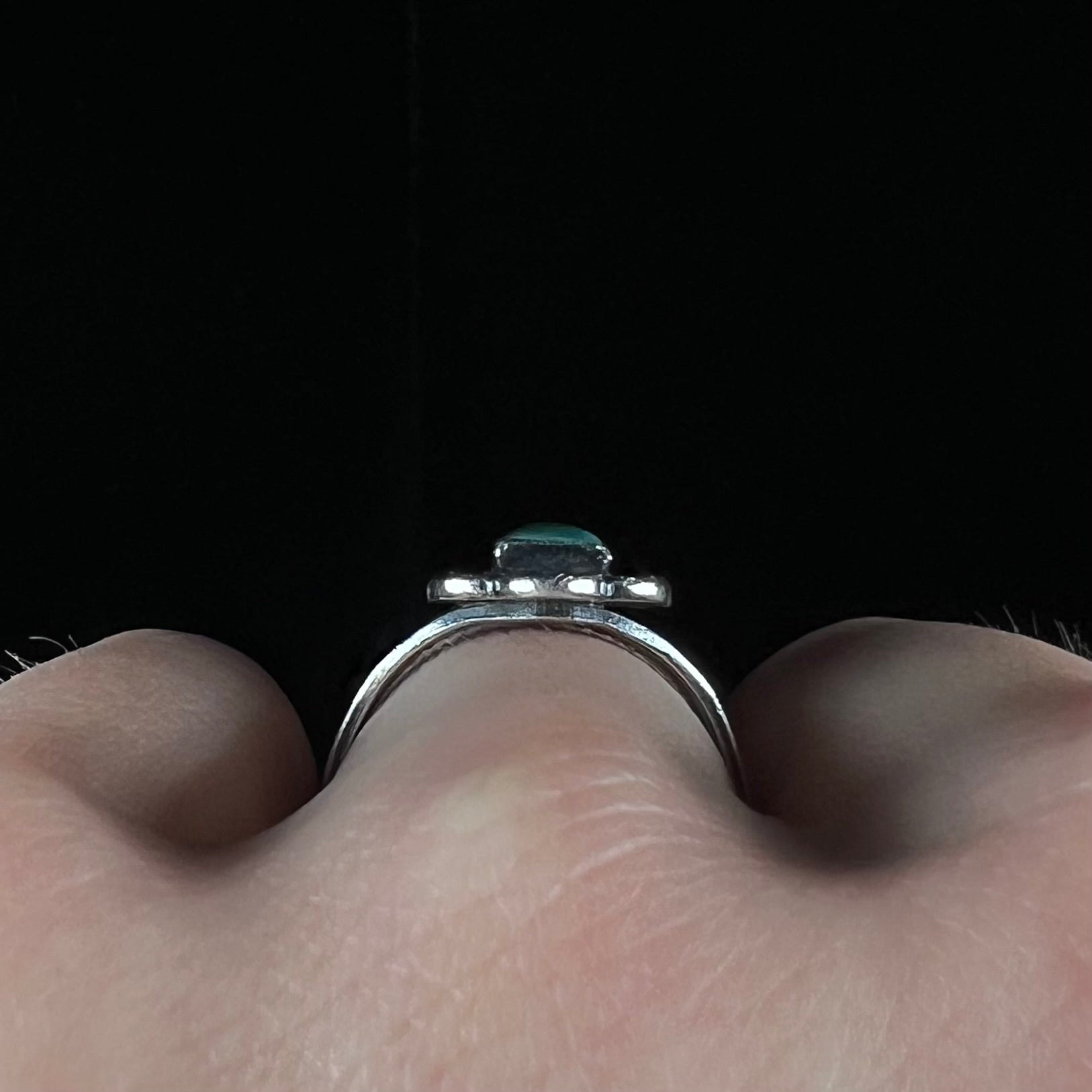 A ladies' silver ring stamped with Southwest style designs and set with a rectangular cabochon cut Royston turquoise stone.