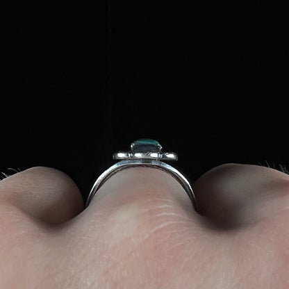 A ladies' silver ring stamped with Southwest style designs and set with a rectangular cabochon cut Royston turquoise stone.