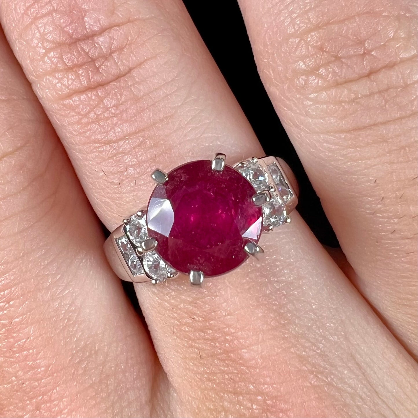 A ladies' sterling silver natural ruby and white zircon ring.  The real ruby is glass filled.