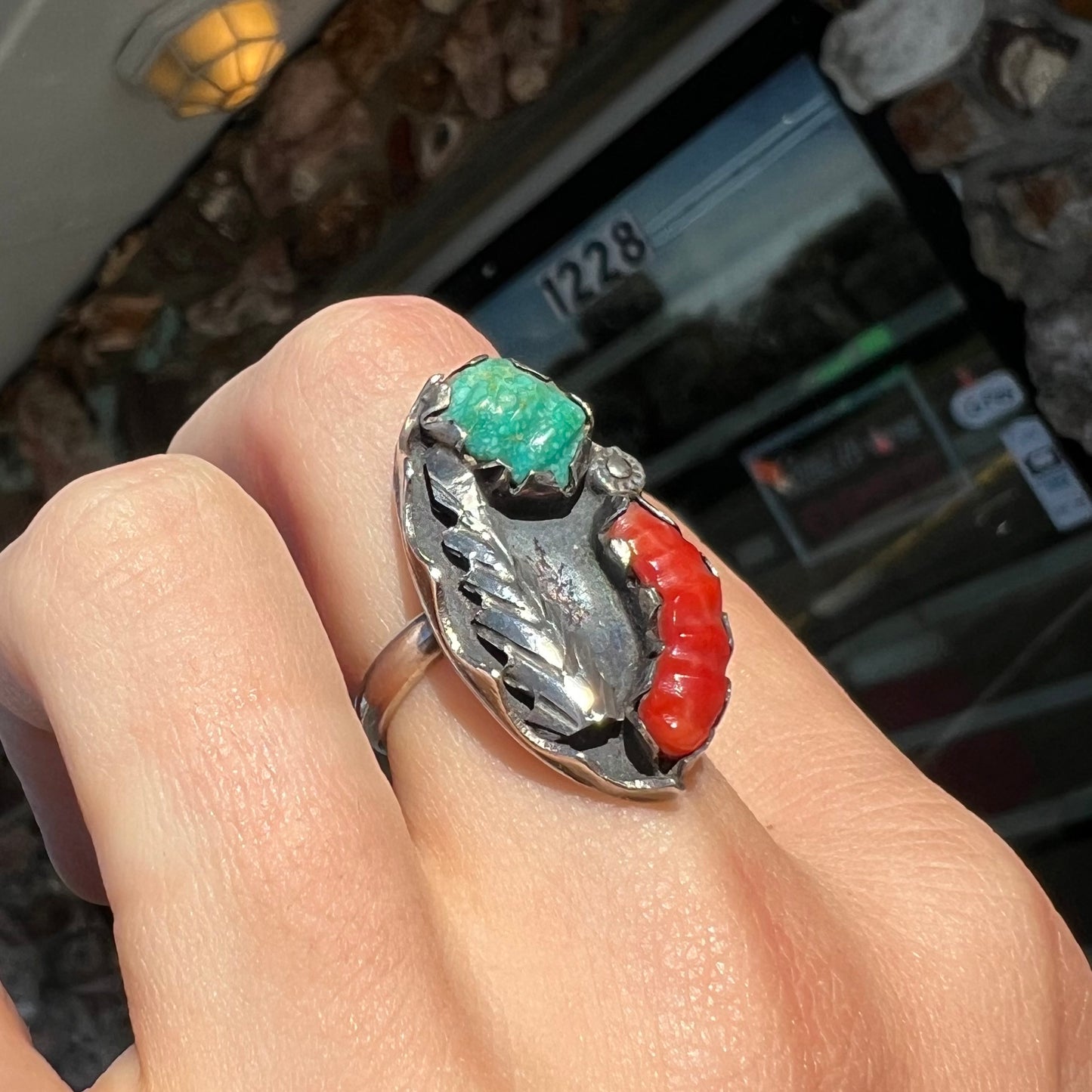A ladies' vintage Southwest silver ring set with carved Royston turquoise and coral stones.