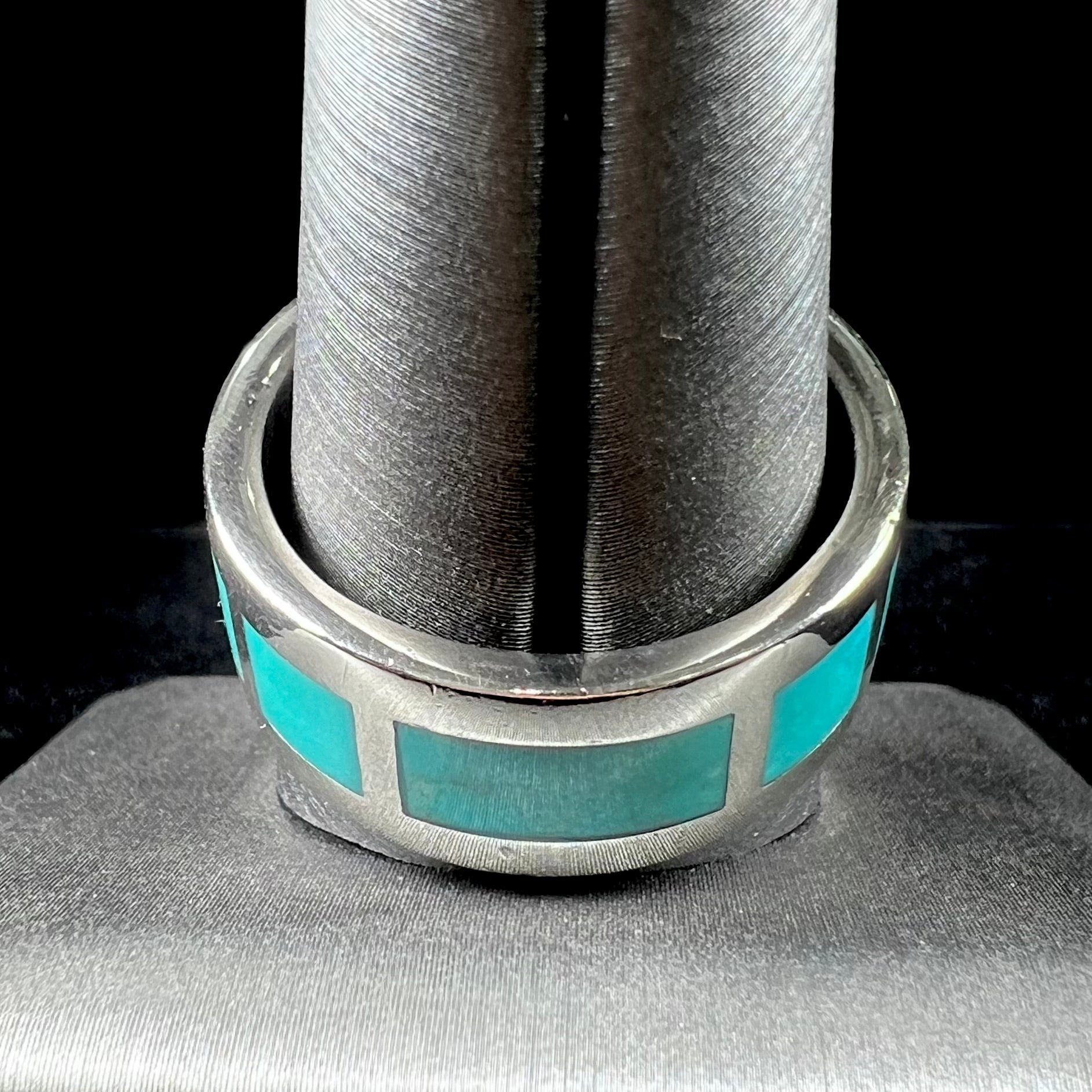 A men's sterling silver wedding band inlaid with natural Sleeping Beauty Turquoise stones that go all the way around.