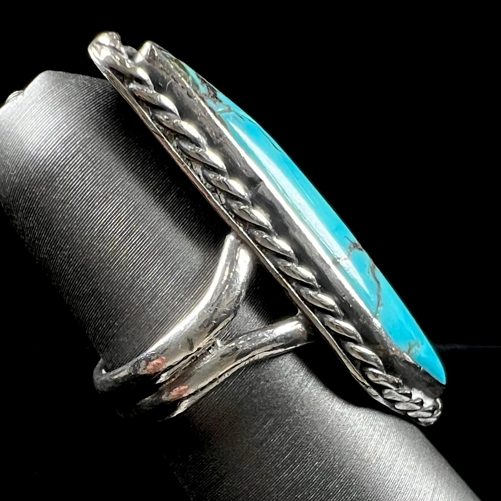 A vintage, Southwest style sterling silver ring set with a natural turquoise stone.  The stone is blue with a black matrix.