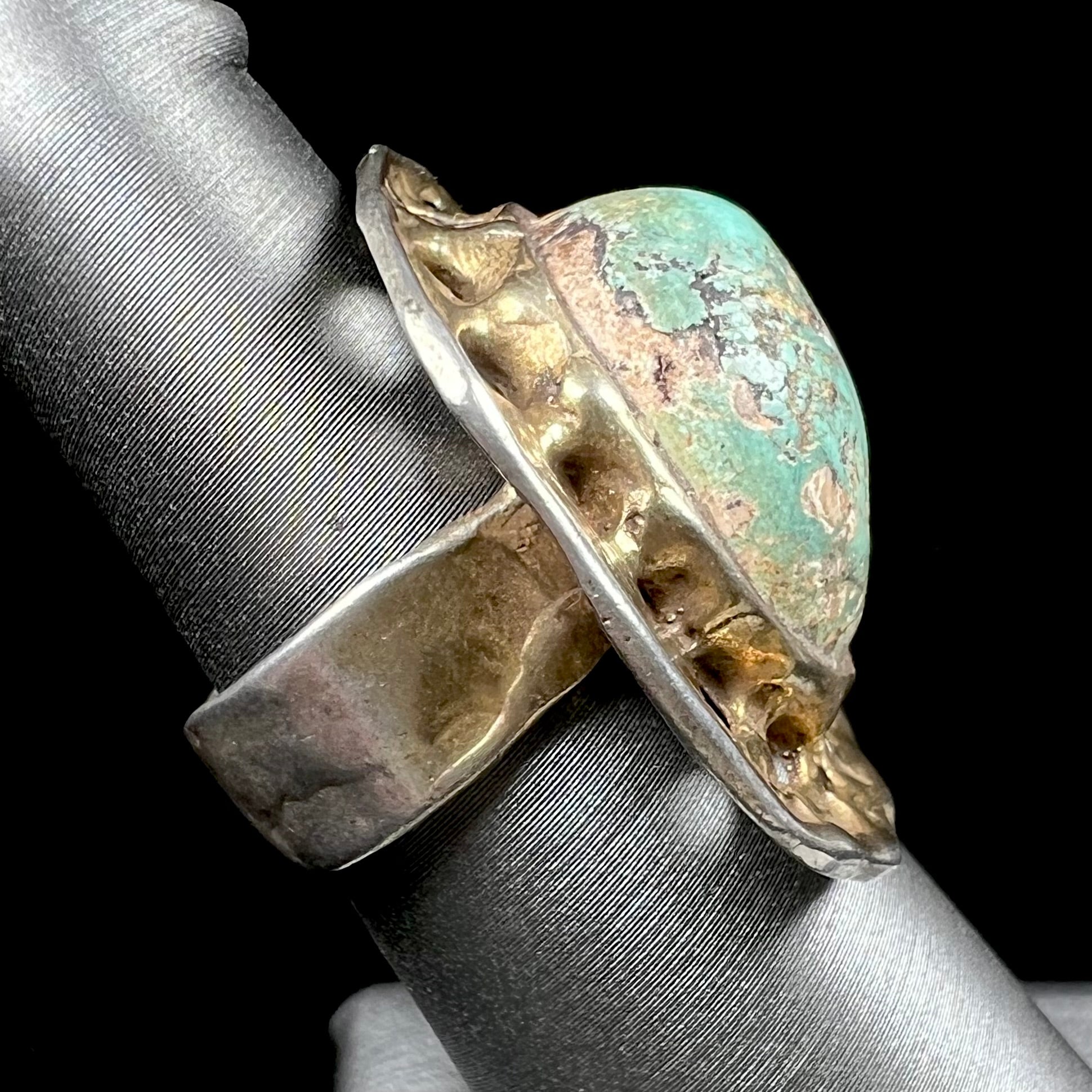 A unisex sterling silver ring with a gold wash, set with a natural, unstabilized Valley Blue turquoise stone.