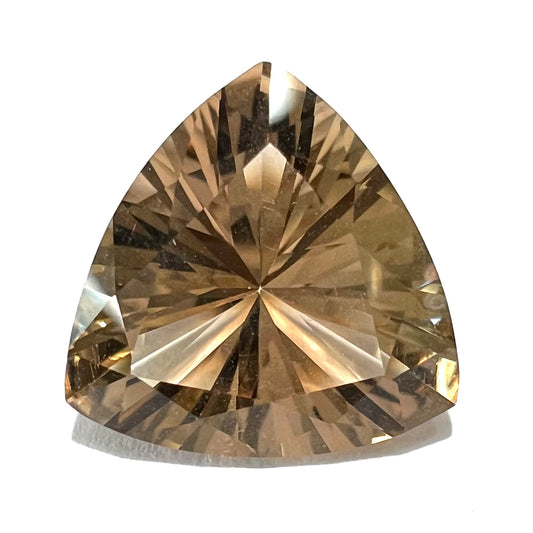A loose, trillion cut smoky citrine gemstone.  The stone is a light golden brown color.