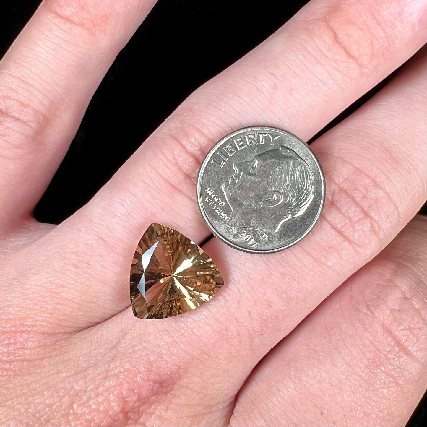 A loose, trillion cut smoky citrine gemstone.  The stone is a light golden brown color.