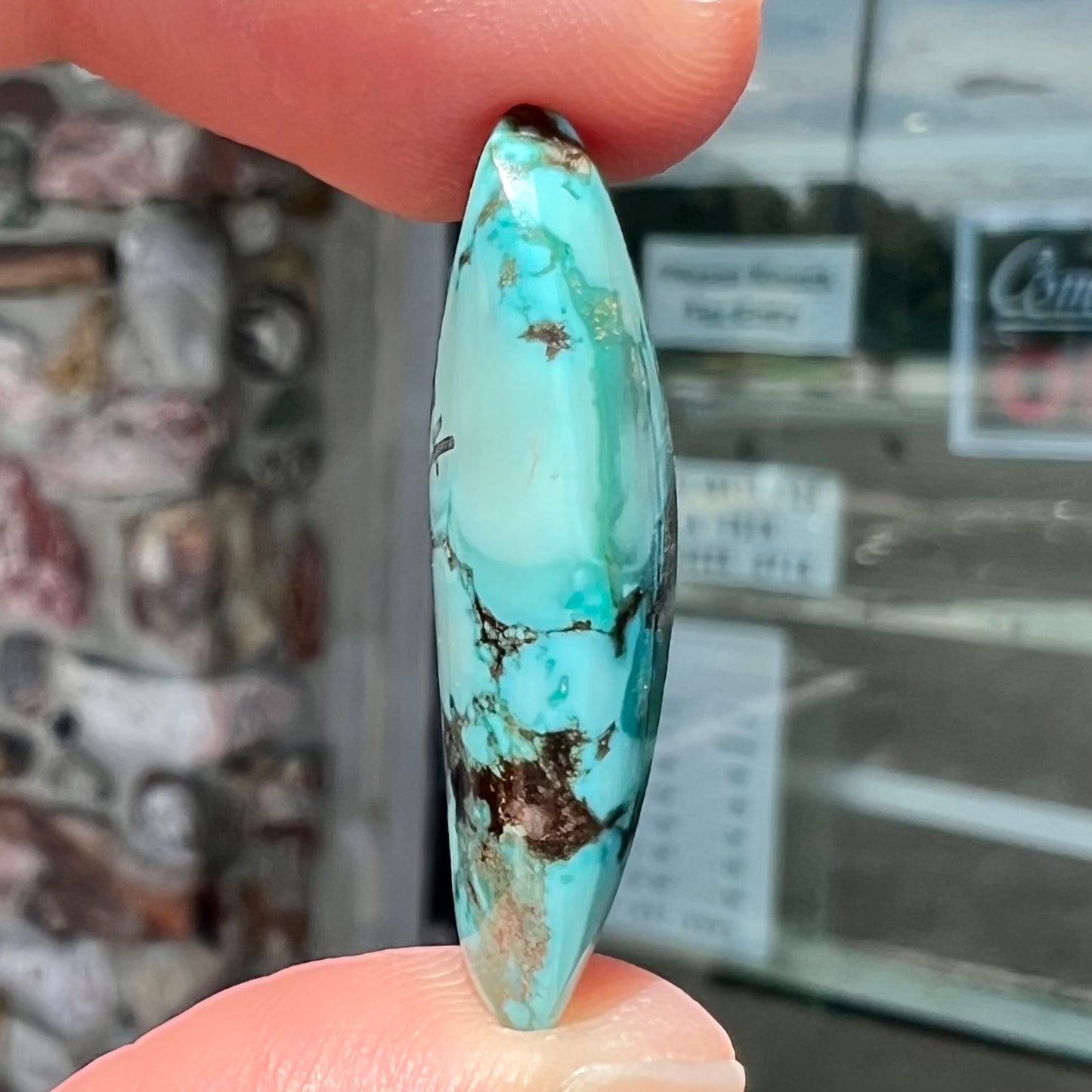 A loose, freeform triangular cabochon cut turquoise stone from Sonora, Mexico.