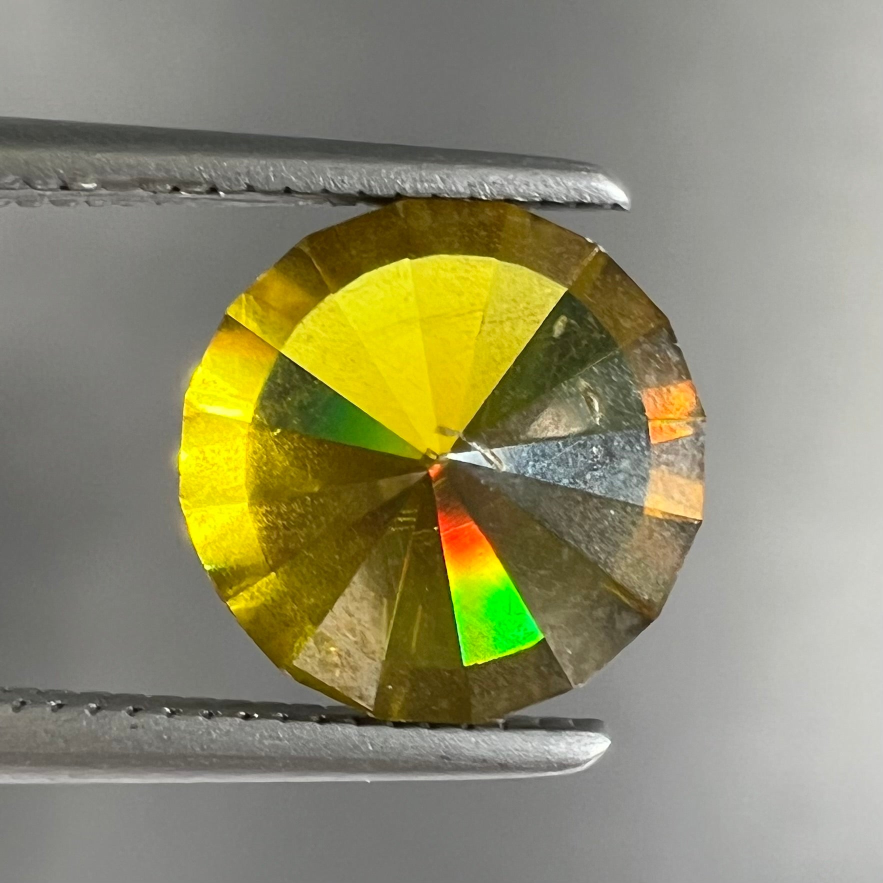 A loose, modified round brilliant cut sphalerite gemstone.