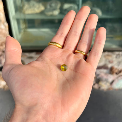 A loose, modified round brilliant cut sphalerite gemstone.