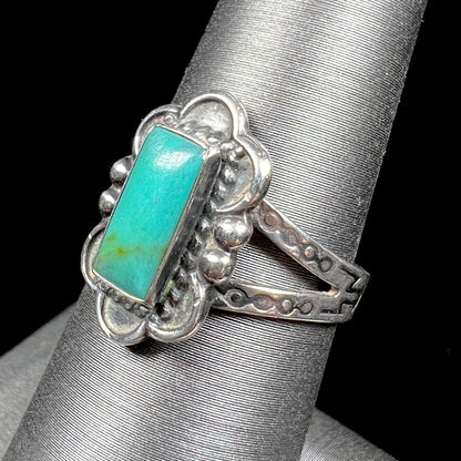 A ladies' silver ring stamped with Southwest style designs and set with a rectangular cabochon cut Royston turquoise stone.