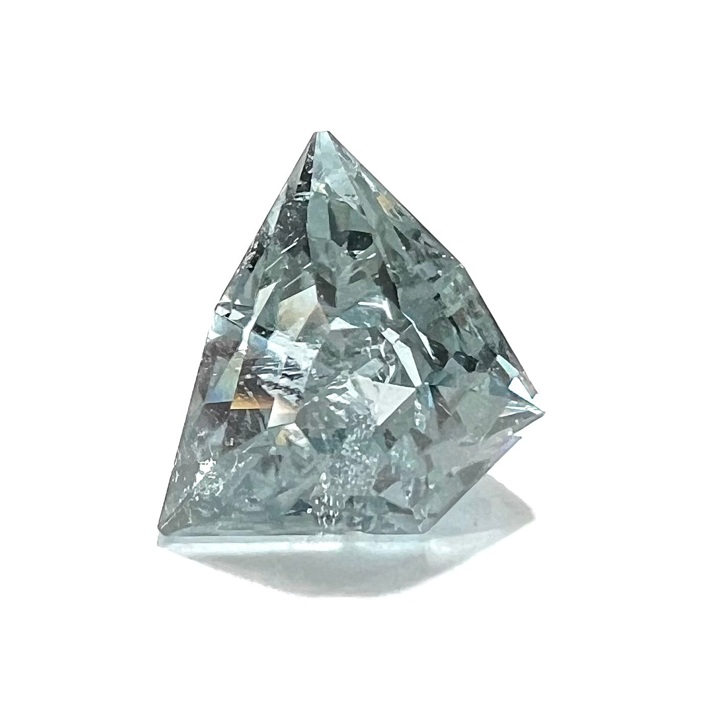 A loose, freeform shield cut tourmaline gemstone.  The stone is a steel blue color.