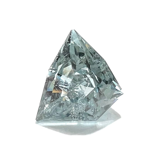 A loose, freeform shield cut tourmaline gemstone.  The stone is a steel blue color.