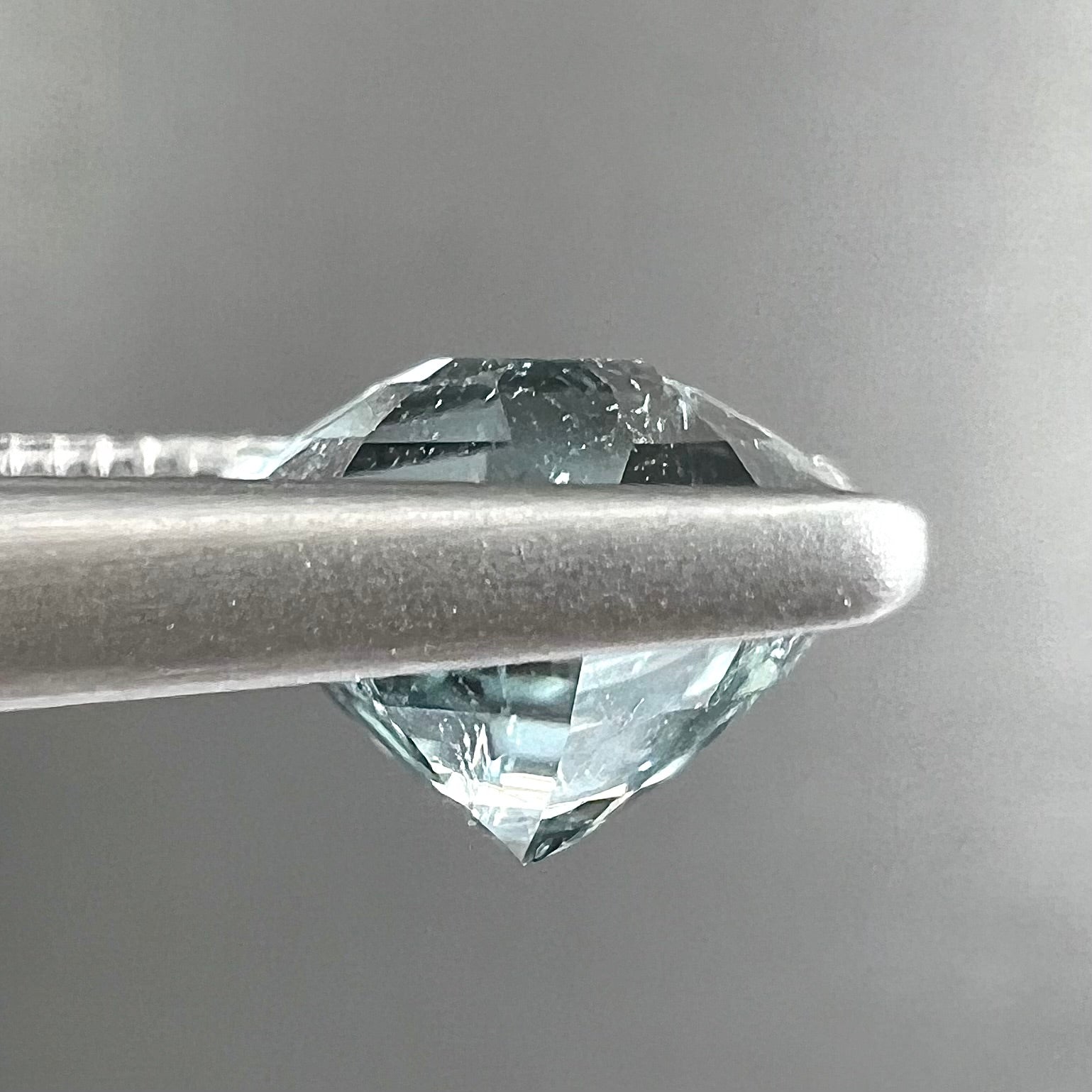 A loose, freeform shield cut tourmaline gemstone.  The stone is a steel blue color.