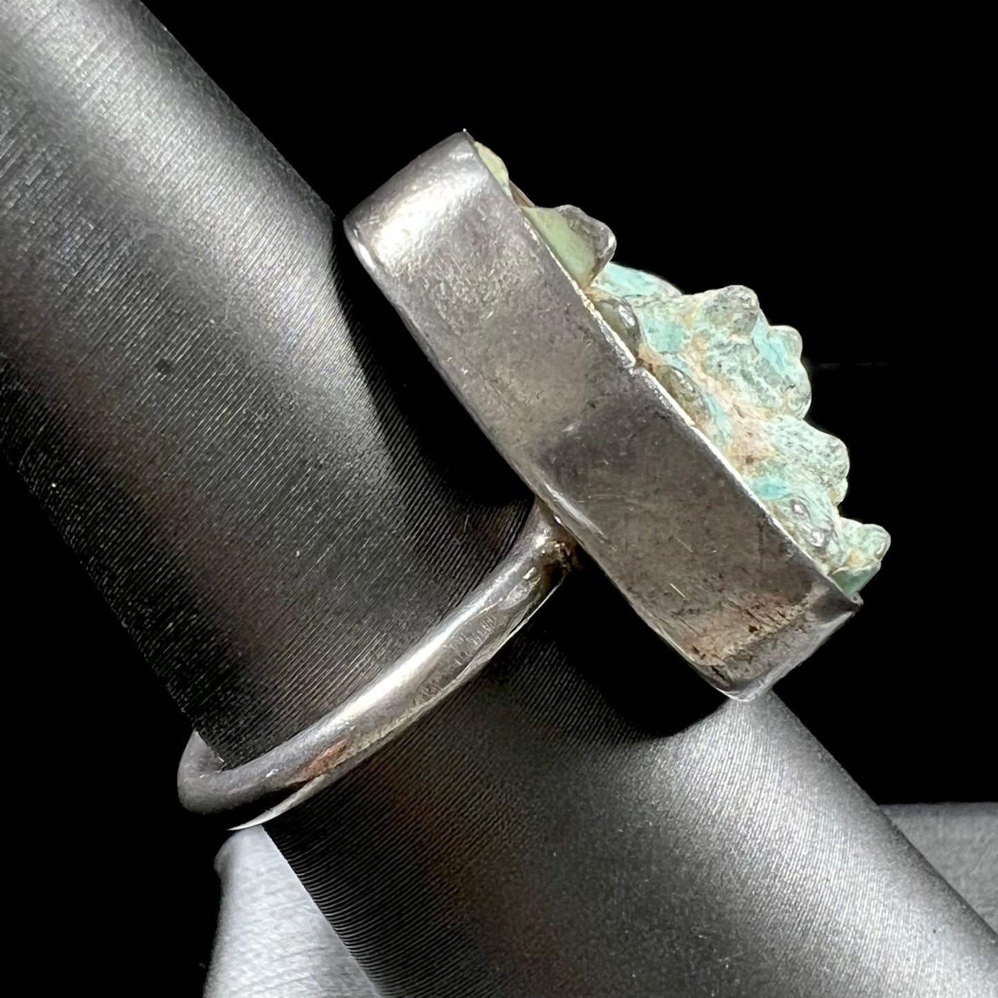 A handmade unisex sterling silver solitaire ring set with a rough, unpolished piece of turquoise stone.