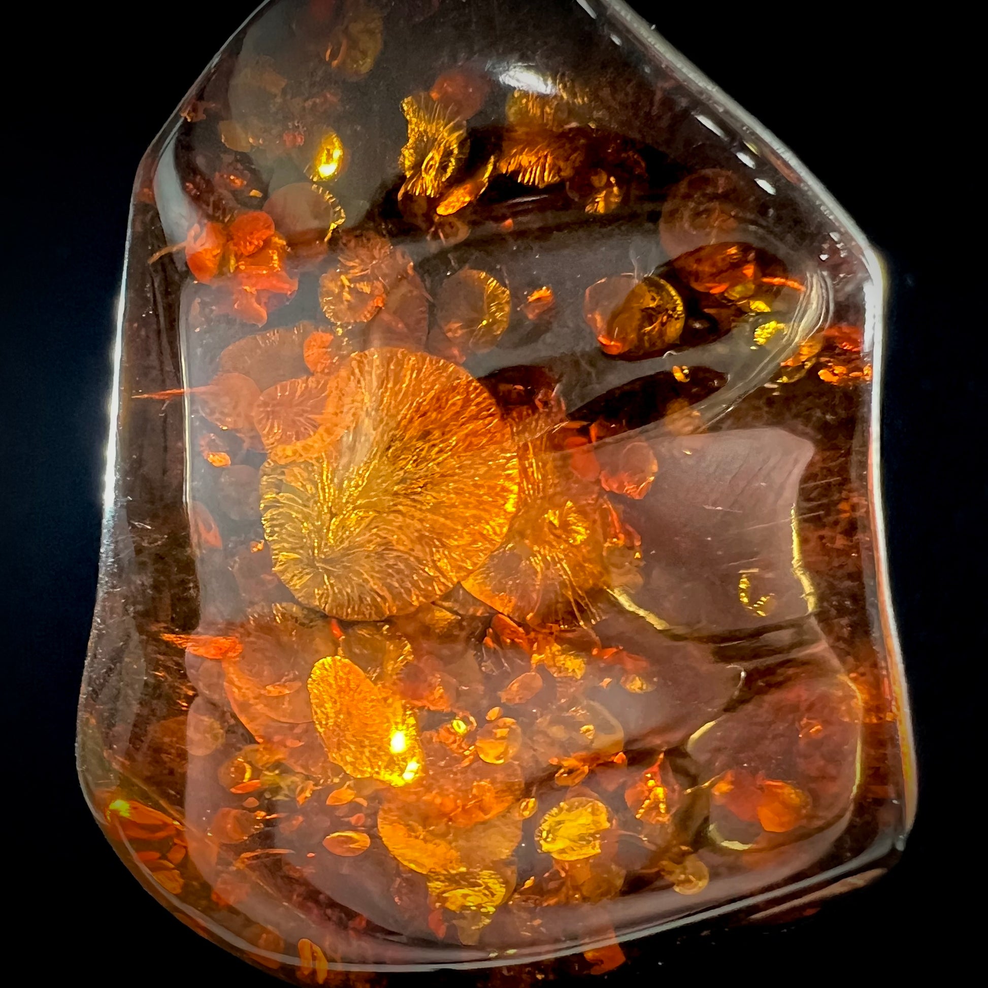 A sterling silver pendant set with a large natural amber stone.  The amber has sun spangled inclusions.
