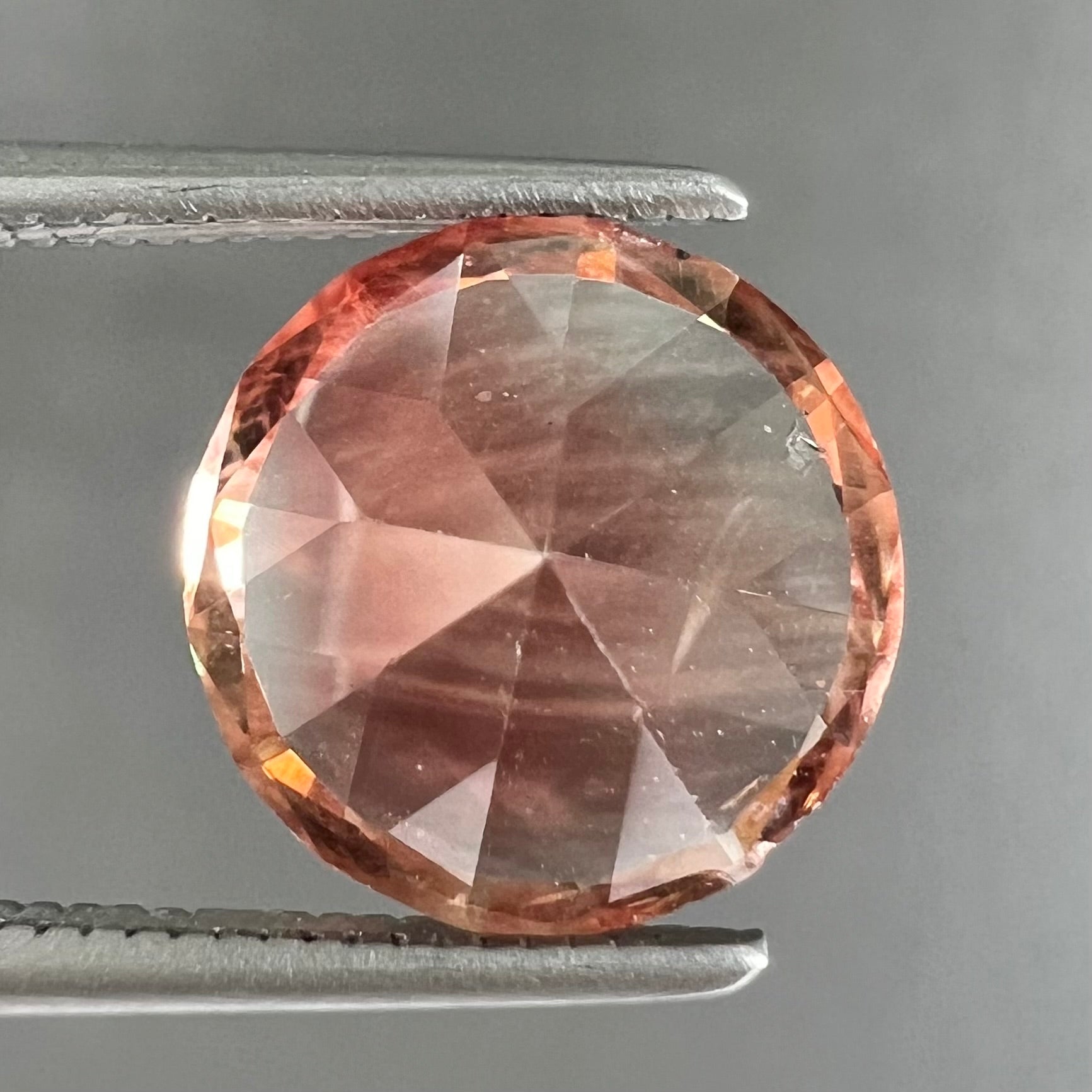 A loose, round brilliant cut Oregon sunstone gem.