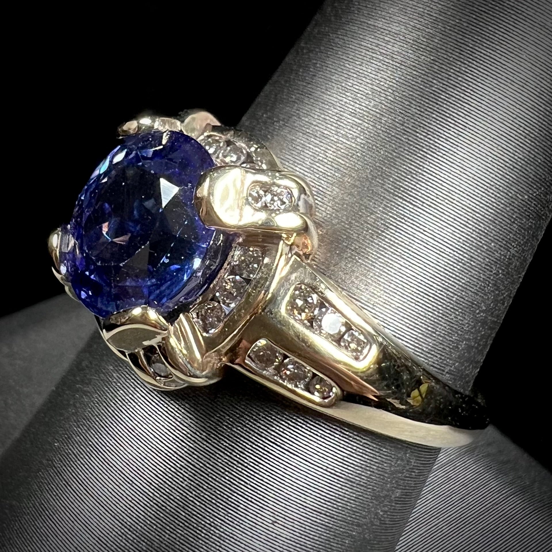 A ladies' yellow gold natural tanzanite and diamond ring.  Diamonds are channel set along the shank and in the prongs.