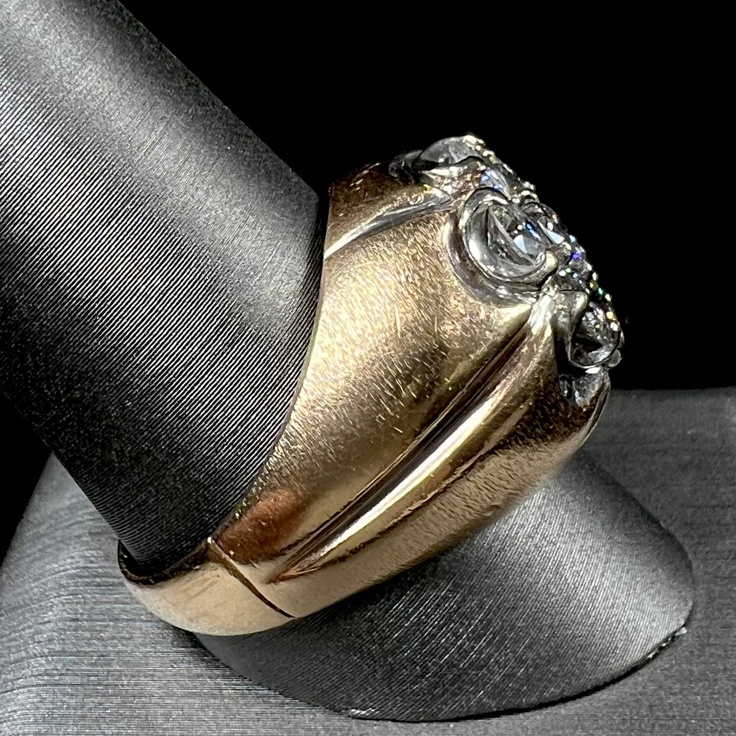 A men's textured yellow gold ring set with a cluster of seven round brilliant cut natural diamonds.