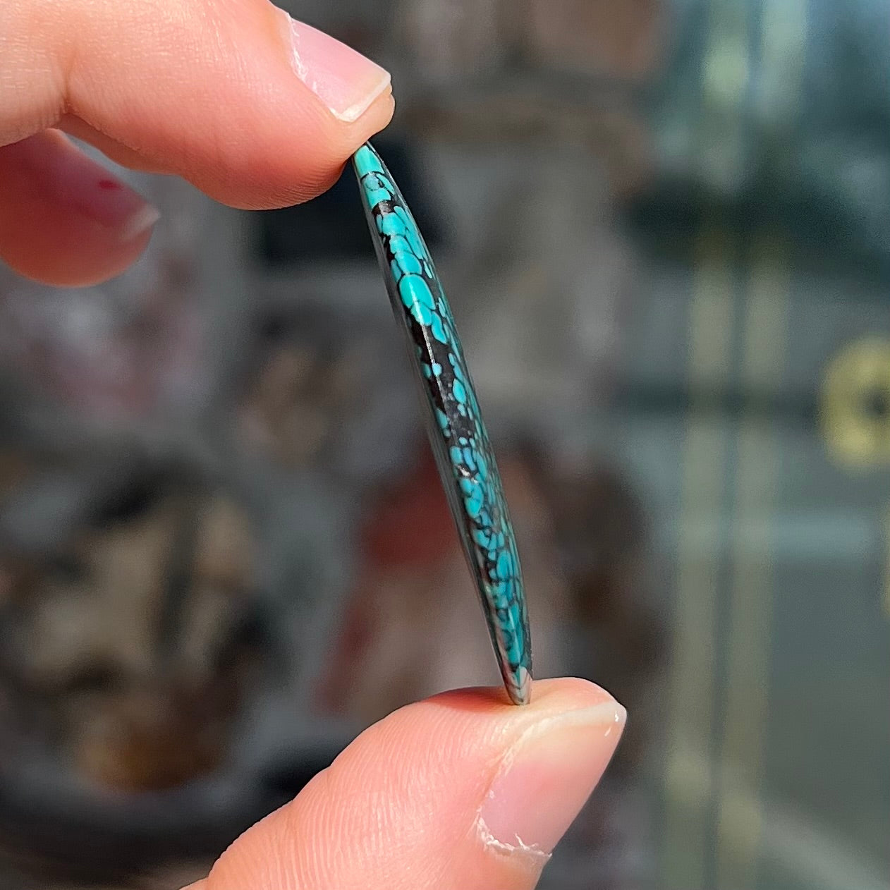 A polished, freeform shaped spiderweb turquoise cabochon from Lone Mountain Mine in Esmeralda County, Nevada.