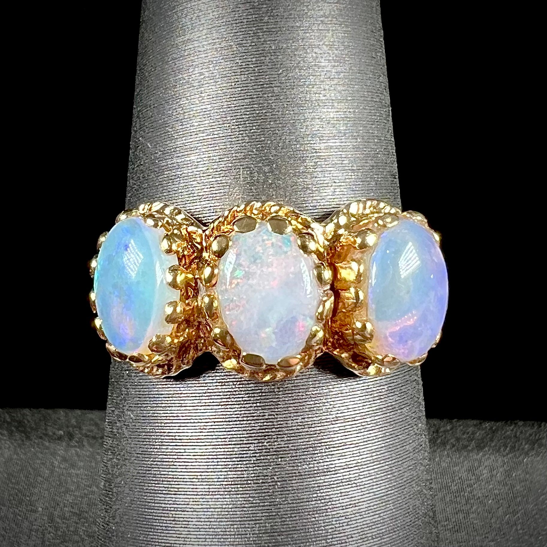 A vintage ladies' three stone gold ring set with natural white crystal opals.