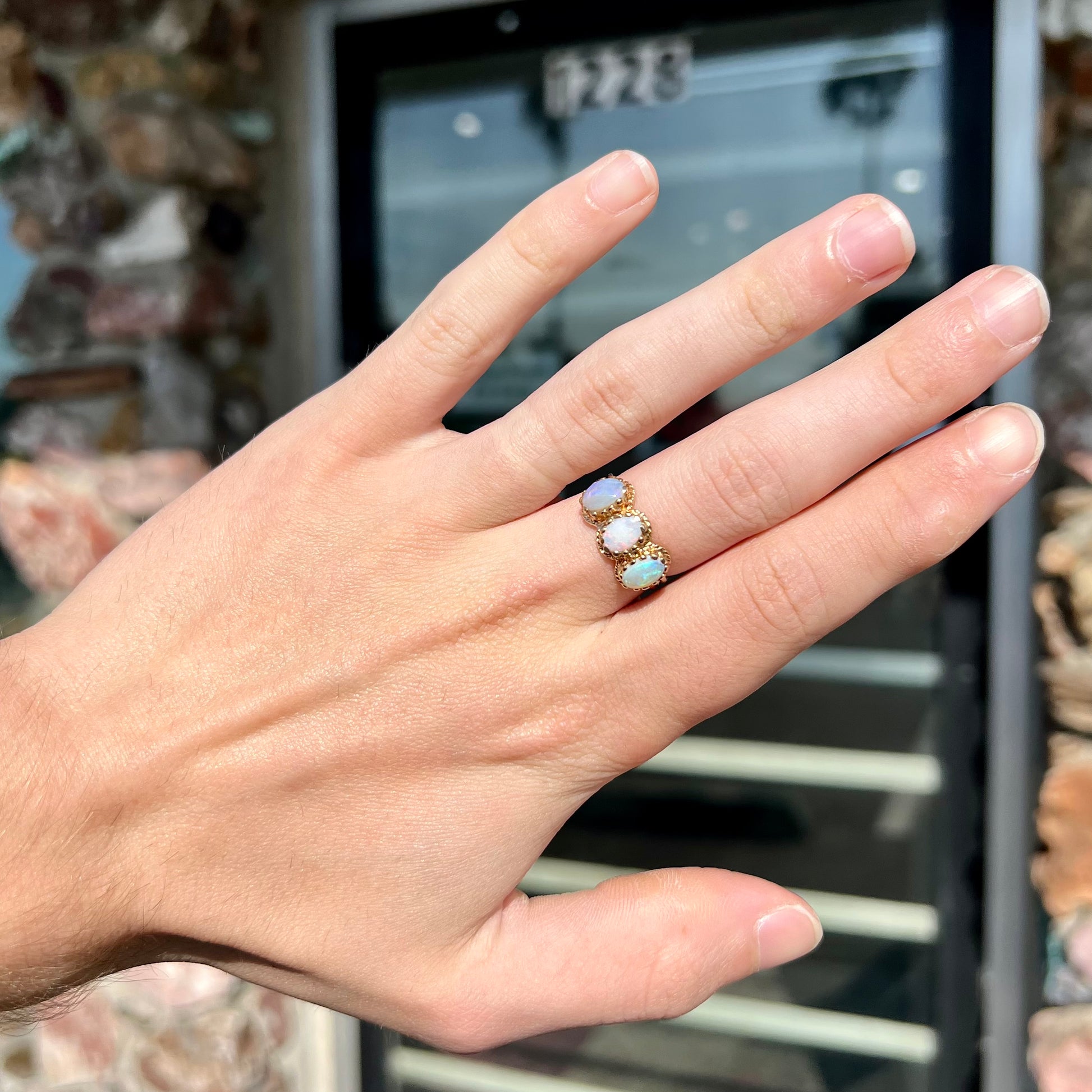 A vintage ladies' three stone gold ring set with natural white crystal opals.