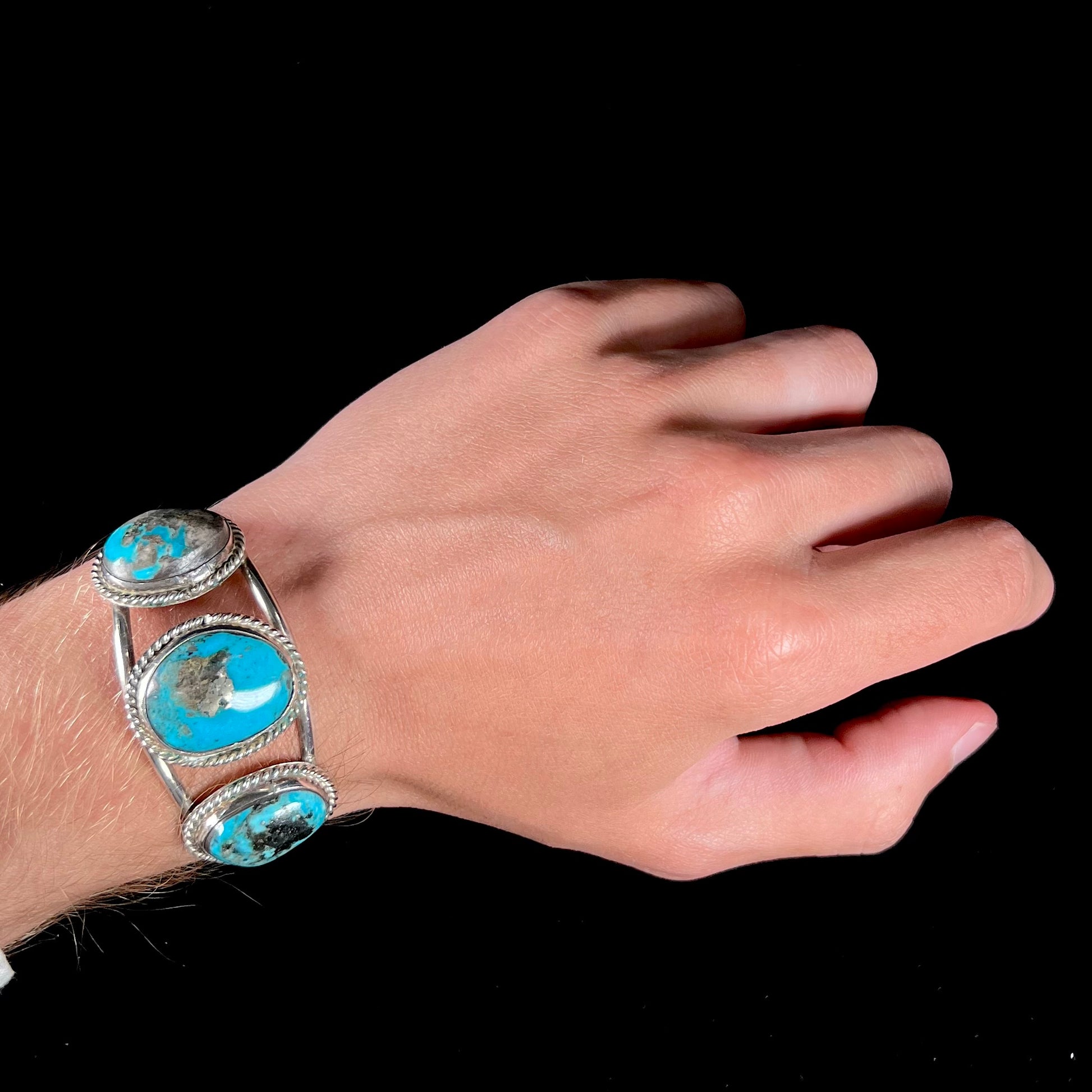 A ladies' three stone silver cuff bracelet accented with rope bezels and set with Morenci turquoise.