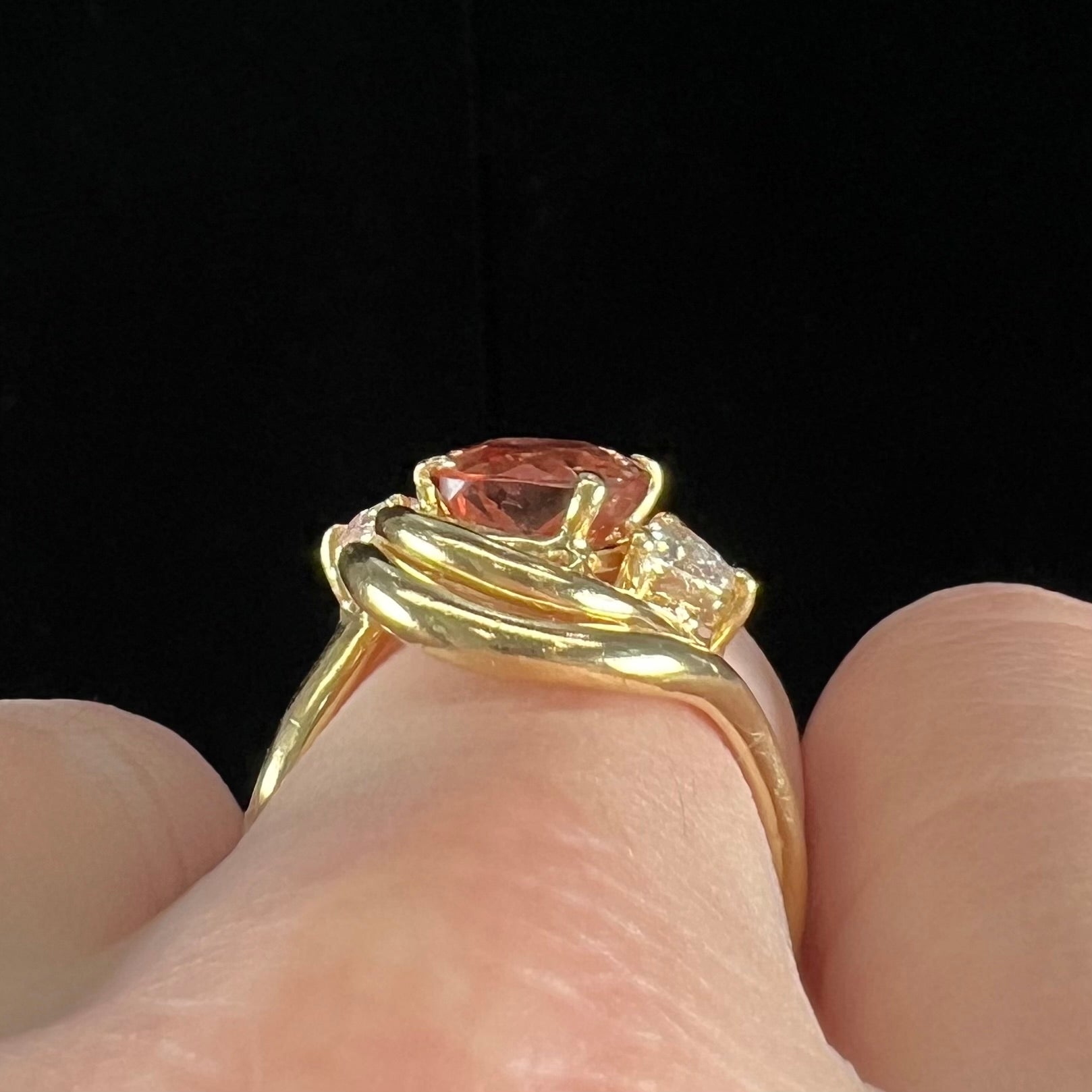 An 18 karat yellow gold ring set with two triangle cut diamonds and a cushion cut imperial topaz.