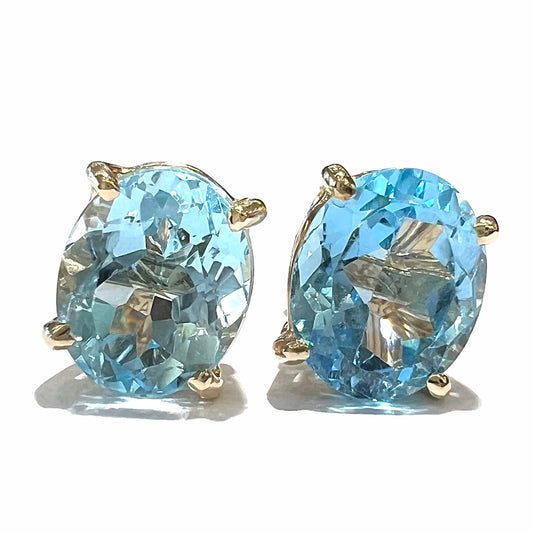 A pair of yellow gold push-back blue topaz stud earrings.