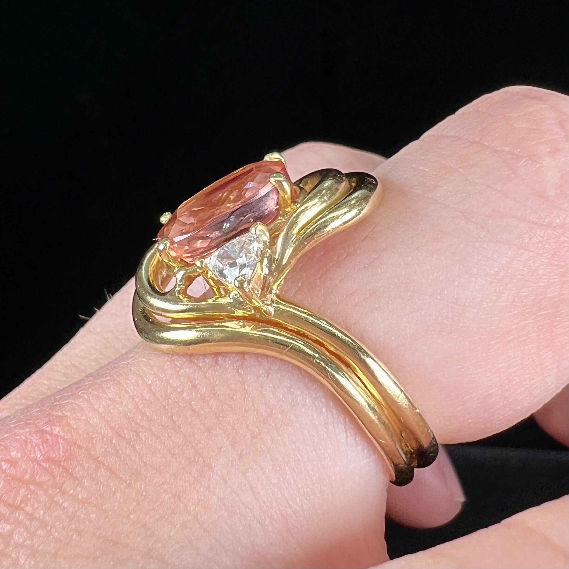 An 18 karat yellow gold ring set with two triangle cut diamonds and a cushion cut imperial topaz.