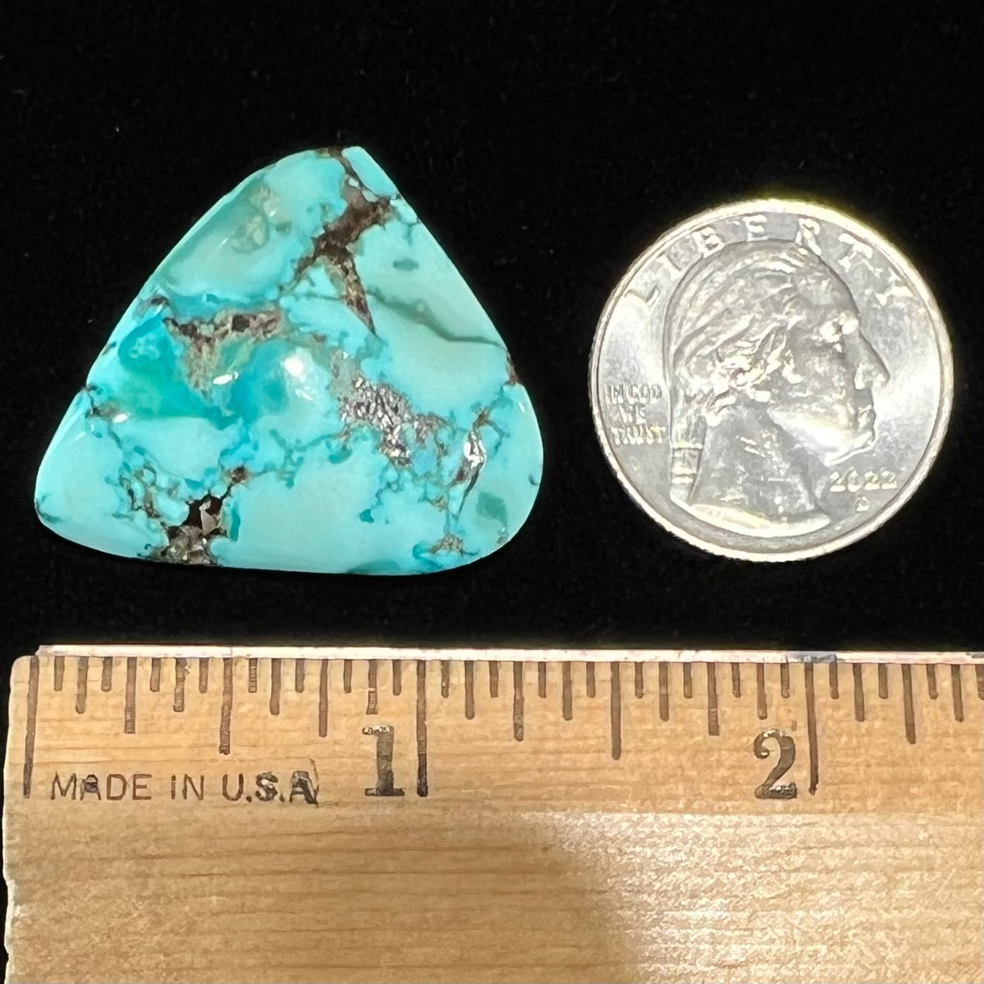 A loose, freeform triangular cabochon cut turquoise stone from Sonora, Mexico.