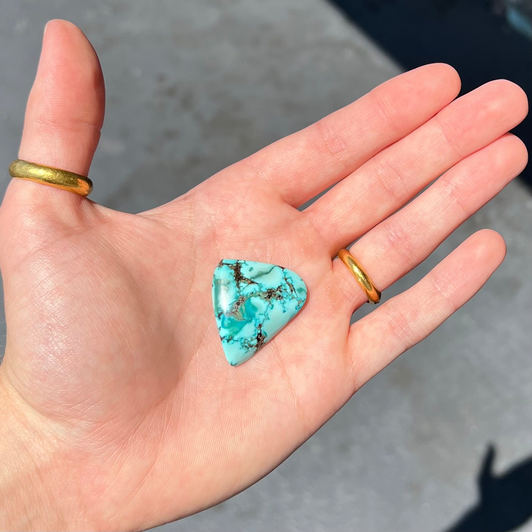A loose, freeform triangular cabochon cut turquoise stone from Sonora, Mexico.