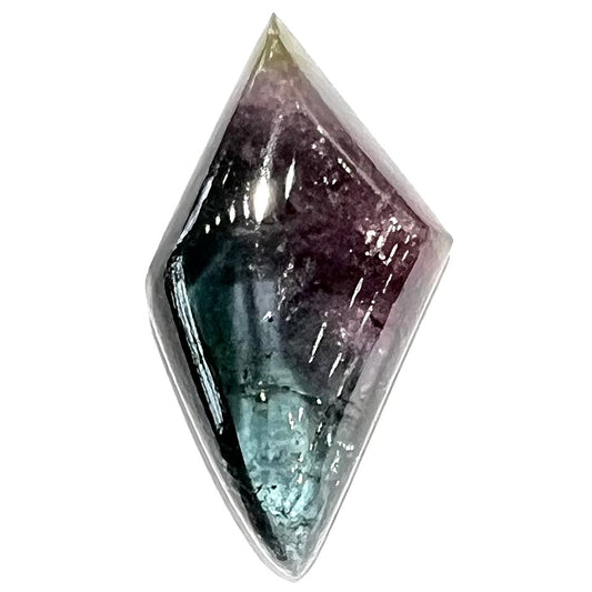 A loose, freeform cabochon cut tricolor tourmaline stone that has blue, pink, and yellow colors.