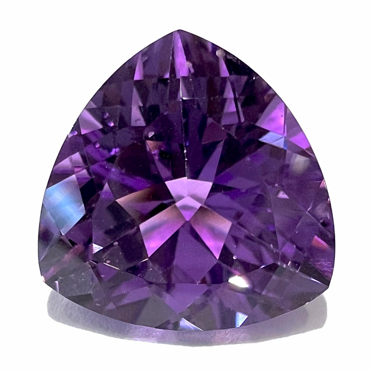 A loose, faceted trillion cut amethyst gemstone.  The gem is a purple color and weighs 8.46 carats.
