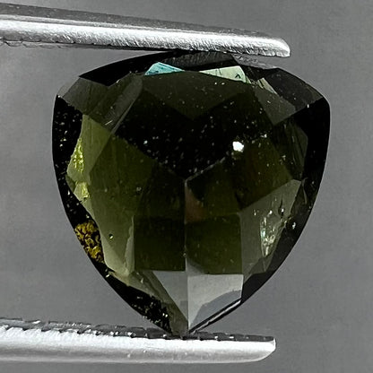 A natural, trillion cut moldavite gemstone.